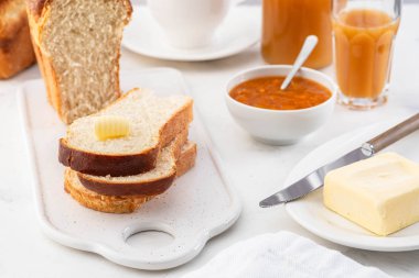 Taze brioche ekmek ve tereyağı, meyve suyu ve reçel. Kıta kahvaltısı.