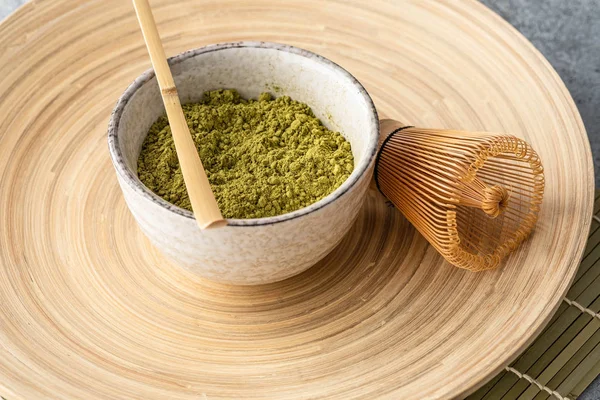 Japanese matcha green tea powder, a healthy natural product, antioxidant. Bamboo spoon and whisk.