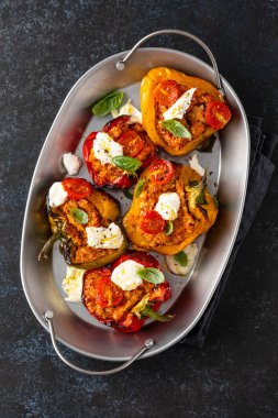 Kıyma, soğan, domates ve mozzarella ile doldurulmuş dolma dolma dolma dolma dolma dolma biber. Karanlık arka plan. Üst görünüm.