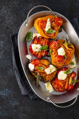 Kıyma, soğan, domates ve mozzarella ile doldurulmuş dolma dolma dolma dolma dolma dolma biber. Karanlık arka plan. Üst görünüm.