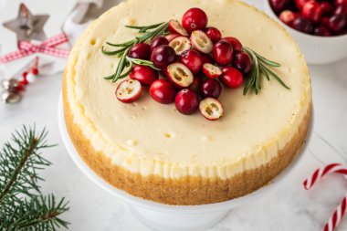 Cheescake taze kızılcık ve biberiye ile. Noel kek dekorasyonu beyaz arka plan üzerinde ile.