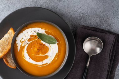 Gri arka planda adaçayı ile kabak çorbası. Üstte görüntü.