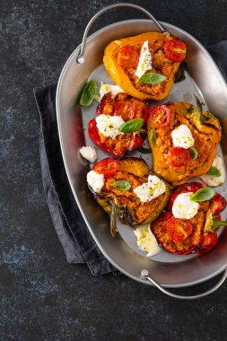 Kıyma, soğan, domates ve mozzarella ile doldurulmuş dolma dolma dolma dolma dolma dolma biber. Karanlık arka plan. Üst görünüm.