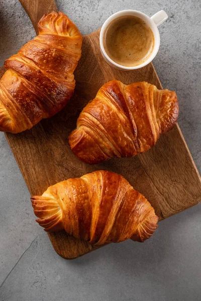 Café da manhã com croissants, tábua de corte e café preto. Deitado plano, vista superior . — Fotografia de Stock