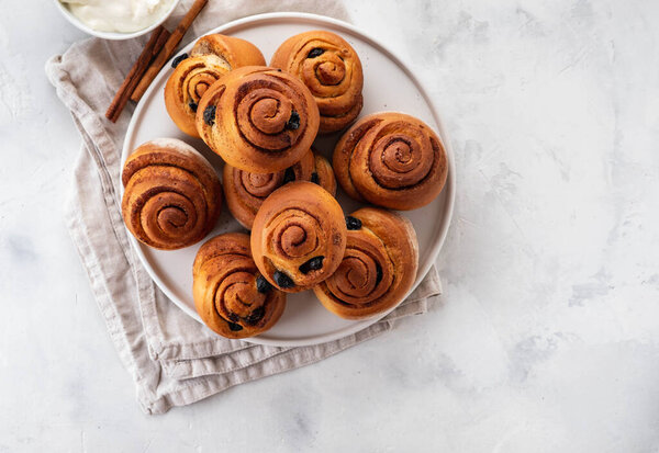 Freshly Baked Traditional Sweet Cinnamon Rolls, Swirl on white plate. Copy space.