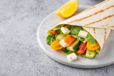 Sandviç paketle, balık somon, sebze ve peynirle yuvarlan. Gri arka plan. Kapat..