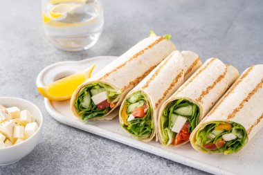 Sandviç paketle, balık somon, sebze ve peynirle yuvarlan. Gri arka plan. Kapat..