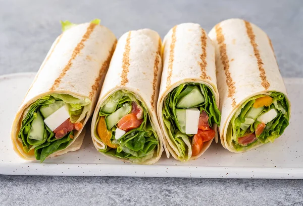 Envuelva el sándwich, rollo con salmón de pescado, verduras y queso. Fondo gris. De cerca. . —  Fotos de Stock