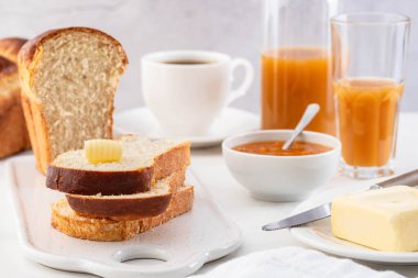 Taze brioche ekmek ve tereyağı, meyve suyu ve reçel. Kıta kahvaltısı.
