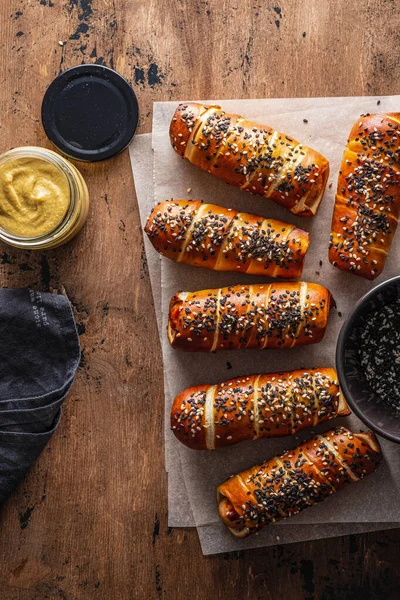 Cães Pretzel com salsichas, com molho ketchup, fundo de madeira. Espaço de cópia. — Fotografia de Stock