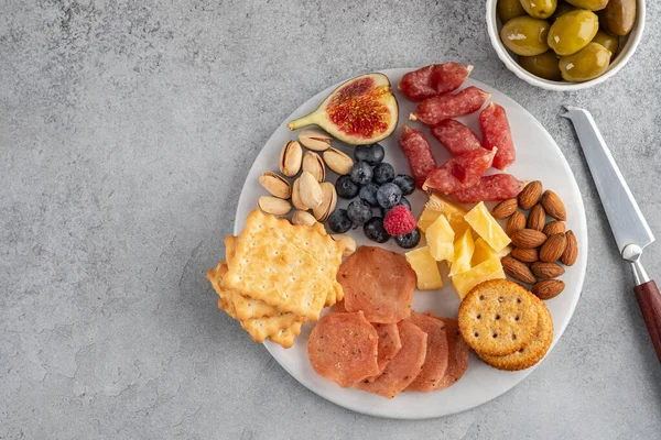 Prato de carne e queijo.Antipasto italiano tradicional, tábua de corte com salame, carne fria defumada, presunto, queijos, azeitonas, alcaparras em fundo branco. Queijo e aperitivo de carne. Vista superior . — Fotografia de Stock