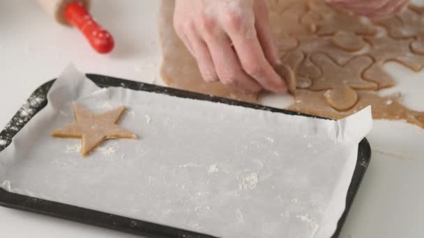 Vrouw snijdt peperkoek koekjes voor kerst. Feest. Peperkoek koekjes maken. — Stockvideo