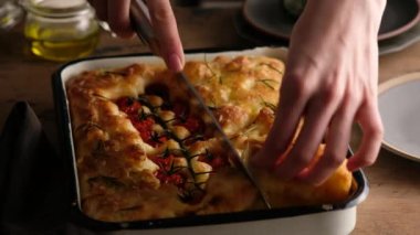 Kadın eli Focaccia, İtalyan ekmeği - zeytin yağı, domates, baharat, biberiye ve deniz tuzu ile Focaccia. Ekmek için Hamur. Focaccia - Pizza hazırlanıyor. Yakın plan..