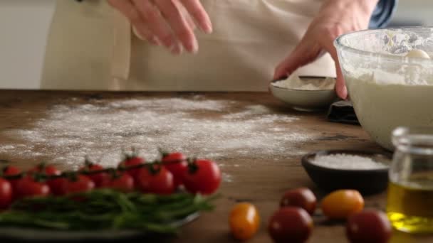 Vrouwelijke handen giet bloem en doe deeg, bereiden Italiaans brood - focaccia met olijfolie, tomaten, kruiden, rozemarijn en zeezout. Moeilijk voor brood. Bereiding van focaccia - Pizza focaccia. — Stockvideo