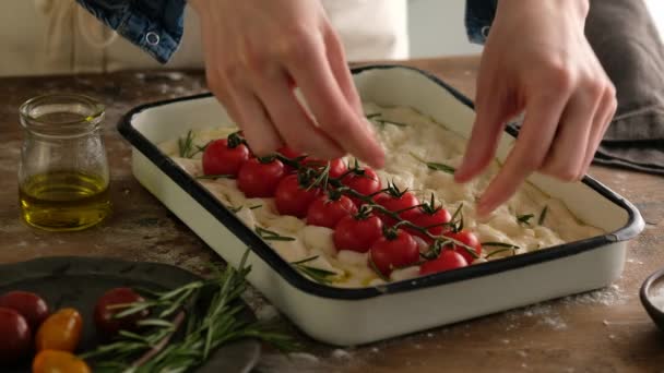Kvinnliga händer lägger en rosmarin i degen, tillagar italienskt bröd - focaccia med olivolja, tomater, kryddor, rosmarin och havssalt. Tillräckligt för bröd. Förberedande focaccia - Pizza. — Stockvideo