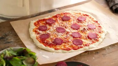 Kadın eli hamura pepperonili sosis koyar, İtalyan pizzasını soslu, domatesli, baharatlı, sosisli, ıspanaklı, yeşillikli, peynirli mozzarella ile hazırlar. Ekmek için Hamur. Pizza Pepperoni..