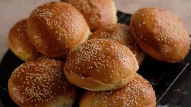 Hamburger için çörek pişiren fırıncı kadın. Fırından sıcak çörekler. El yapımı ekmek. Çörek pişirmek için hamur hazırlıyorum. Hamuru pişirmek için çörek, ekmek hazırlıyorum. Güzel arka plan. Yavaş çekim.