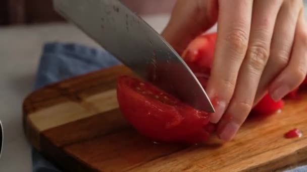 Kvinna händer med hjälp av kökskniv skära färsk tomat på trä skärbräda. Hälsosam mat. Skivad tomat. — Stockvideo