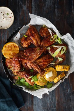 Teriyaki soslu tavuk kanadı doğranmış maydanoz ve mısırla süslenmiş susam tohumları. Üst görünüm.