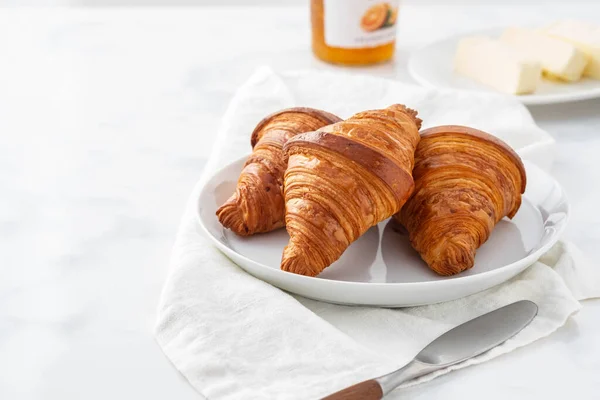 Petit déjeuner avec croissants, thé et confiture d'orange. — Photo