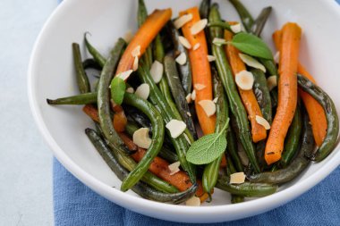 Zeytin yağı ve adaçayı ile pişirilmiş havuçlu yeşil fasulye. Sağlıklı yemek..