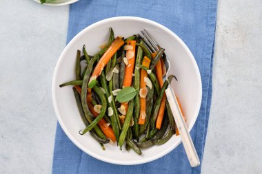 Zeytin yağı ve adaçayı ile pişirilmiş havuçlu yeşil fasulye. Sağlıklı yemek..