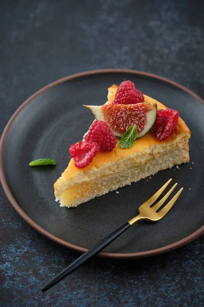 Siyah arka planda ahududu ve incirli cheesecake..