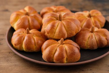 Kahverengi arka planda baharatlı balkabaklı çörekler. Cadılar Bayramı Yemek Konsepti. Sonbahar konsepti.