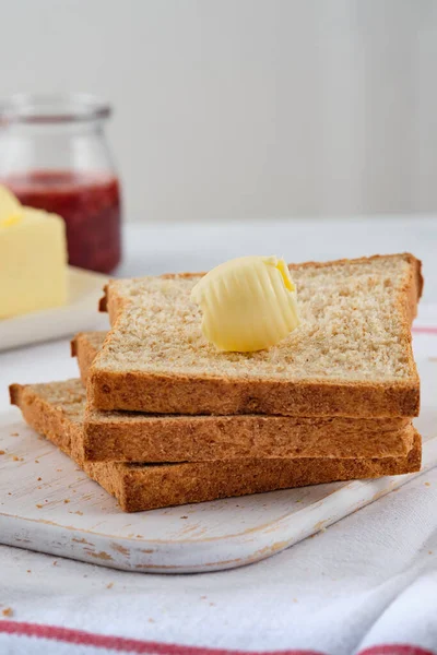 Boucles de beurre sur pain grillé. Petit déjeuner sain avec pain grillé au son, beurre et confiture. — Photo