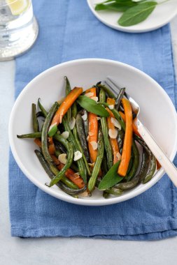 Zeytin yağı ve adaçayı ile pişirilmiş havuçlu yeşil fasulye. Sağlıklı yemek..
