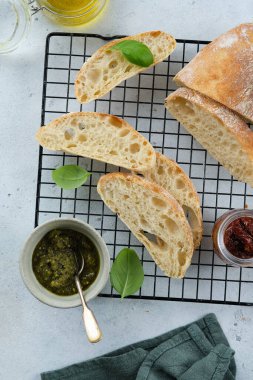 Akdeniz atıştırmalıkları hazır. Zeytin, yağ, bitkiler ve dilimlenmiş ciabatta ekmeği. Üst görünüm.