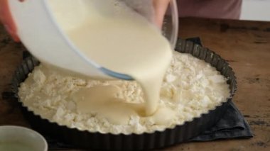 Yunan peynirli turta. Kadın peynirli turta hazırlıyor. Siyah arkaplan.