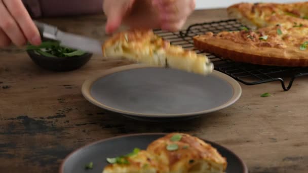 Torta de queijo grega. Mulher corta tarte. A mulher prepara uma torta com queijo feta e microverdes. Fundo preto. — Vídeo de Stock