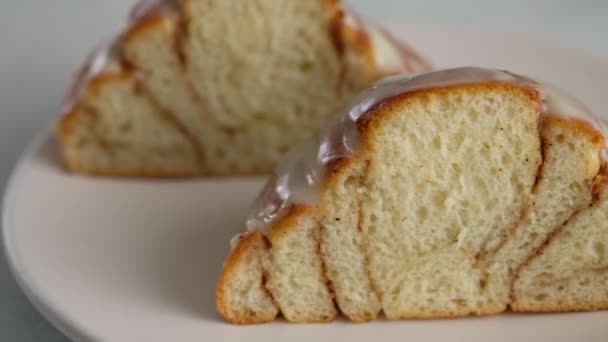 A redução de close-up de rolos de canela em uma chapa. Queijo creme doce cobertura derramando em rolos de canela. Produção de rolos de canela. Produtos de padaria. Pães de canela apetitosos — Vídeo de Stock