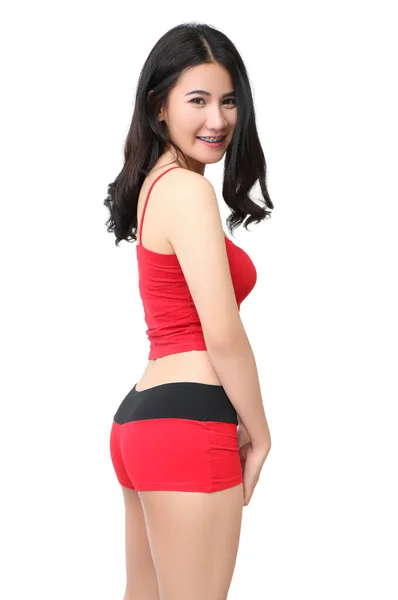 白い背景に赤いスポーツウェアを着た美しいアジア系女性 ストック画像