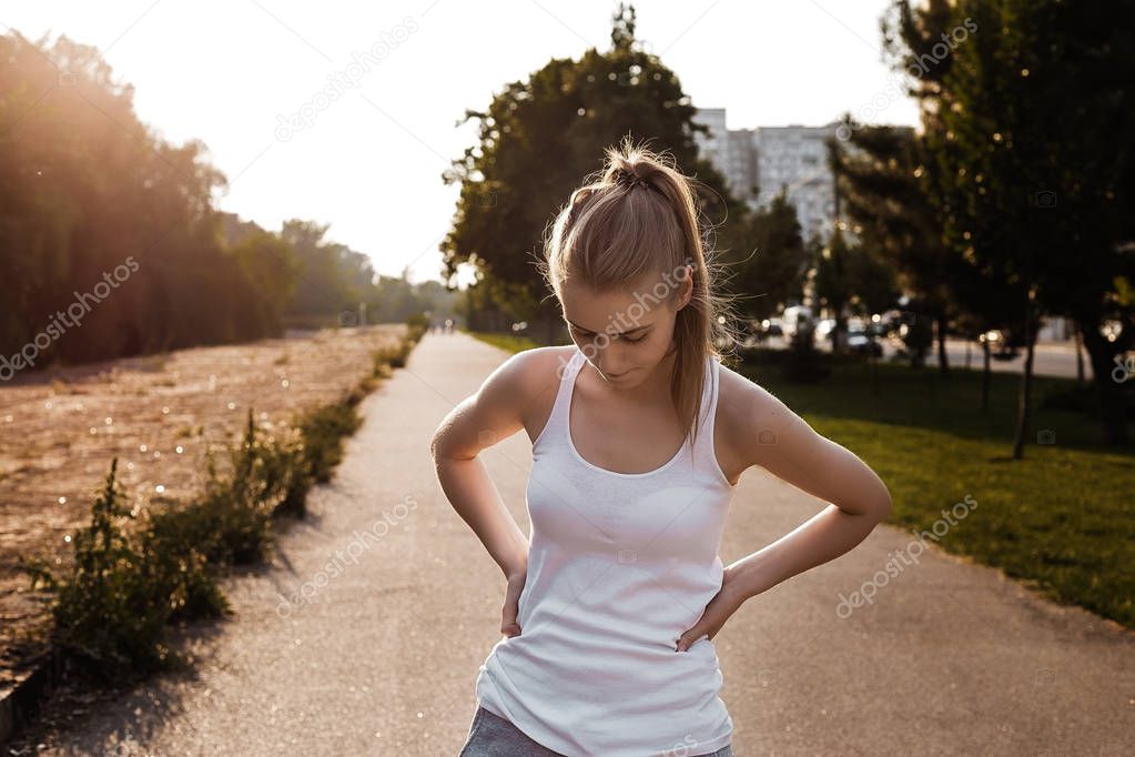 Girl jogging on the road. Pretty young woman loss weight and doing sport exercise outdoor.