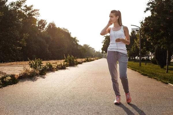 Yolda koşu spor genç kız. Sarı saçlı yapmak kardiyo açık olan güzel kadın.