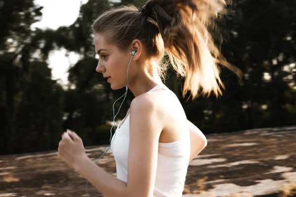 Yolda koşu spor genç kız. Güzel kadın sarışın saç yapmak kardiyo ile. Fotoğraf taşı. Açık.