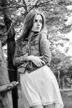 Güzel model duran ve üzerinde ahşap eskrim eğilerek sarı saçları ile. Ellerini karnına çarpı işareti vardır