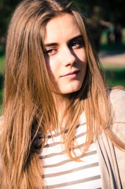 Güzel ve sarışın genç kız portresi. Kız kameraya kendine güvenen bakışla bakıyor. Açık. 