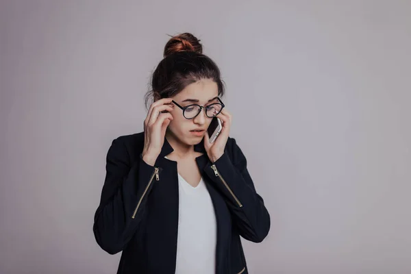 I have not heard can you repeat again? Woman with confused look talking on the phone. The girl looks shoked and alarmed after hearing.