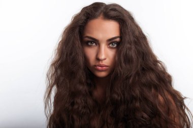 Aslan yelesi gibi saçlı model. Uzun kıvırcık dalgalı kahverengi saçlı Genç ve güzel kadın portresi. Komik surat.