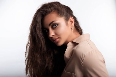 Kadın boynunu öne eğiliyor. Güzel kadın kahverengi Karamel tenli. Kameraya bakarak modeli