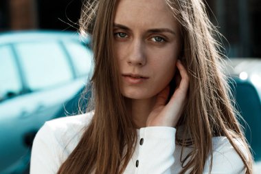 sarı saçlı çok güzel bir genç kadının yatay portresi. Model kameraya bakıyor. Sokakta poz veren kız. Büyük fotoğraf