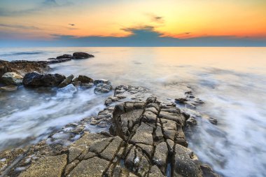 Adriyatik Denizi kıyısında Istria Hırvatistan 'da kayaları olan bir plajda renkli bir gün batımı
