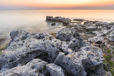 Adriyatik Denizi kıyısında Istria Hırvatistan 'da kayaları olan bir plajda renkli bir gün batımı