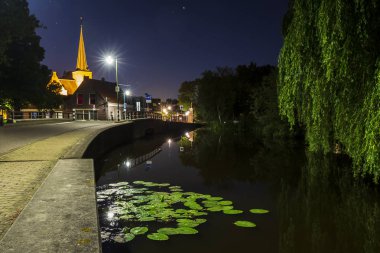 Yaz aylarında akşam karanlığı sırasında küçük bir kanal boyunca Hollanda köyü Zoeterwoude-dorp.