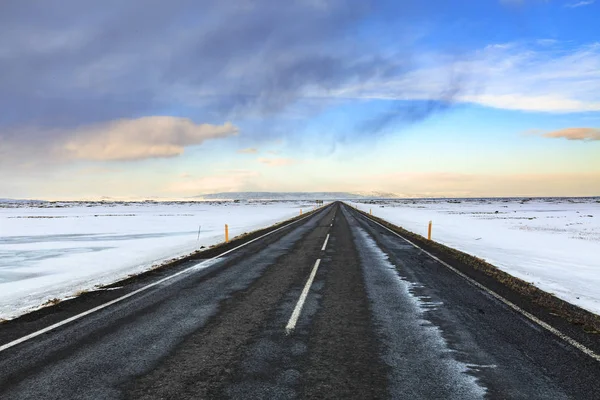 Güney İzlanda rota 1 yol karlı kış aylarında gün batımı, dramatik gökyüzü ve karlı dağlar, yatay.