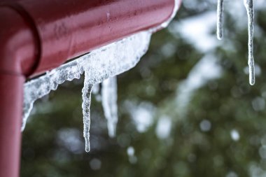 Kar ve buz sarkıtları bir fiyort üzerinde dağlarda bulunan tipik geleneksel kutup kırmızı ev.