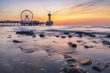 Colorful sunset on coastline, beach, pier and ferris wheel, Sche clipart